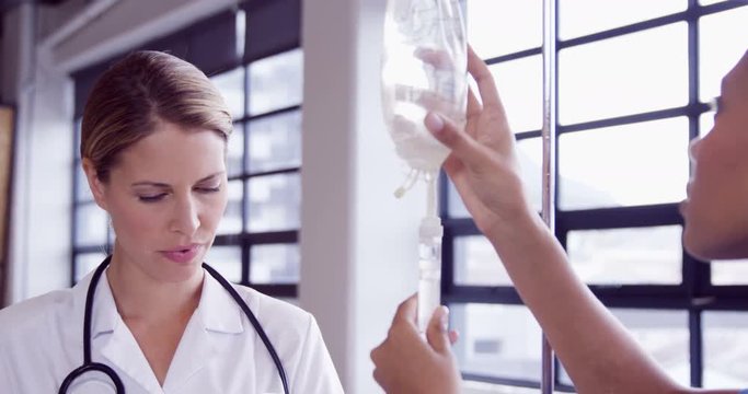 Doctor and nurse examining intravenous drip together