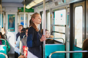 Young woman travelling in a train of Parisian underground - obrazy, fototapety, plakaty
