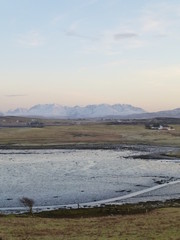 Fototapeta na wymiar Winter sunset on the Isle of Skye with the Cuillin Hills in the distance and Loch Roag at low tide in the foreground