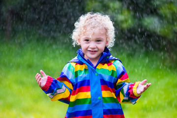 Little boy playing in the rain