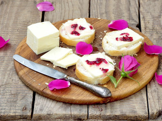 sandwiches with cream cheese and jam of tea roses on a wooden board