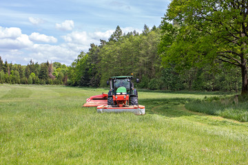 Image of a tractor on meadow. Early grass cutting for BIOGAS production © vaclavkrizek