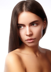 Fototapeta premium Beautiful young woman with clean face, shiny skin, fashion natural make-up, perfection eyebrows. Cute bun hairstyle. Spa portrait, naturel cosmetics, healthy fresh look