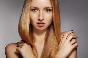 Fototapeta premium Beautiful young woman with clean skin, beautiful straight shiny hair, fashion makeup. Glamour make-up, perfect shape eyebrows. Portrait sexy blondy. Beautiful smooth hairstyle. Shiny nail polish