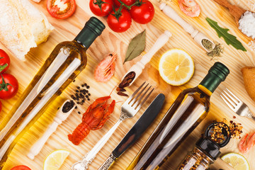 Fototapeta na wymiar Different spices and silverware between glass bottles of olive oil
