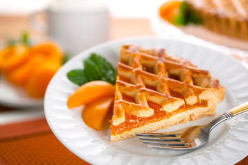 Apricot peach pie tart on wooden table with organic natural fruit background