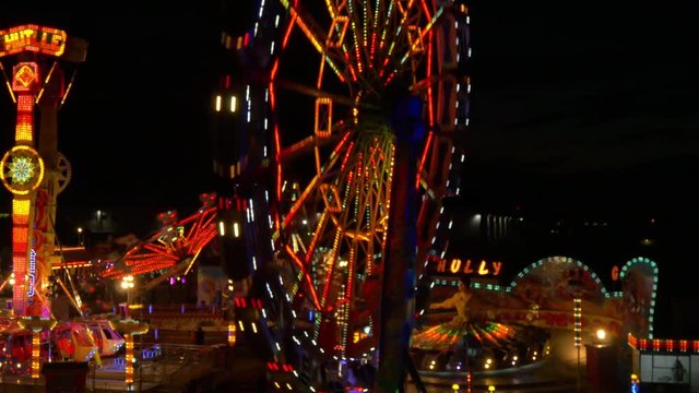 AERIAL: Flying over spinning Ferris wheel in Luna park