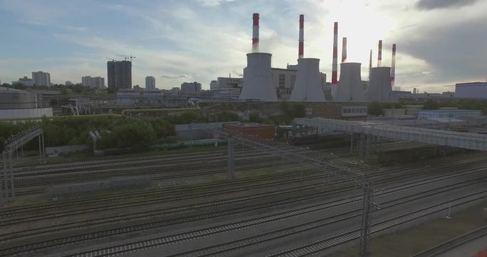 Aerial 4K: Pollution concept, Smoke or Steam from an Industrial Chimney, Thermal Power Plant with Huge Cooling Towers and Steam situated in the City, Industry Scenery, Factory View. 