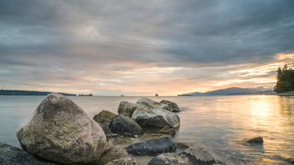 Fototapeta na wymiar beach rocks with sunset cloud sky