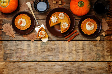 wooden background with pumpkin pies, pumpkin and coffee. Autumn
