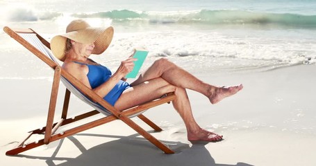 Retired old woman reading book while lying on deckchair on the beach - Powered by Adobe