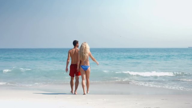 Video of cute couple walking on the beach 
