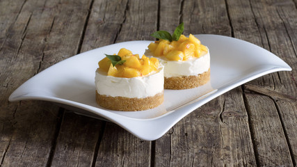 Cheesecake with peaches on wooden background