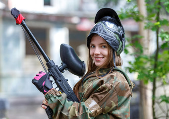 Beautiful girl posing in paintball ammunition outdoors