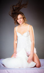 Fototapeta premium Woman on bed with pillow and wind in hair.