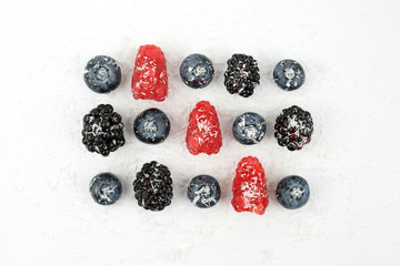 Obraz na płótnie Canvas blueberries, blackberries and raspberries sprinkled with coconut
