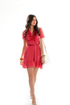 Girl in short summer dress. Casual dress of red color. Bead necklace and stylish bracelets. Attractive female model.