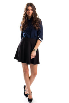 Woman in navy shirt. Black skirt and watch. Cotton clothing and suede heels. Smart casual outfit with accessory.