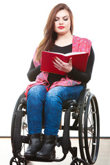 Young disabled woman in wheelchair with book.