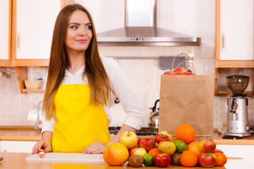 Obraz na płótnie Canvas Woman housewife in kitchen with many fruits