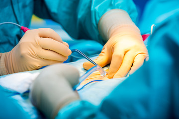 Surgeons hands while operating their pacient with serious trauma