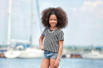 Fototapeta na wymiar Afro American little girl wearing stylish clothes outdoors. Fashion kid concept