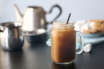 Iced coffee in glass jar on black table