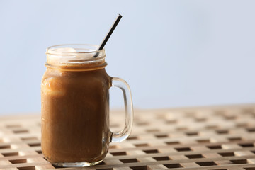 Iced coffee in glass jar on wooden table
