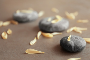 Spa stones with petals on grey background