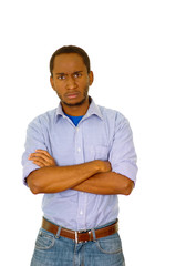 Handsome man wearing jeans and light blue shirt standing in front of camera with serious facial expression, white studio background