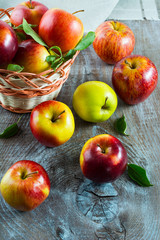 Fresh apples in the wicker basket on the rustic background