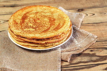 Stack of fresh crepes on a wooden table