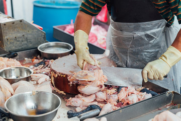 Butcher separates pieces of raw chicken for sale