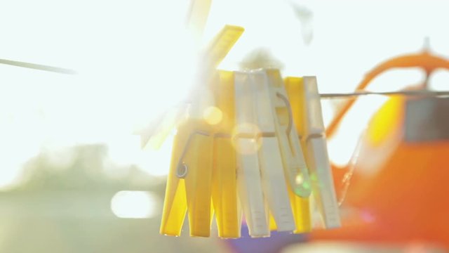 clothes pegs, Sunset light, golden hour, sun lens flare. Close-up shot