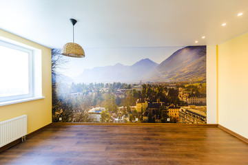 Interior of an empty room in orange tones with a panorama photo wall mural Merano (South Tyrol, Italy) - obrazy, fototapety, plakaty