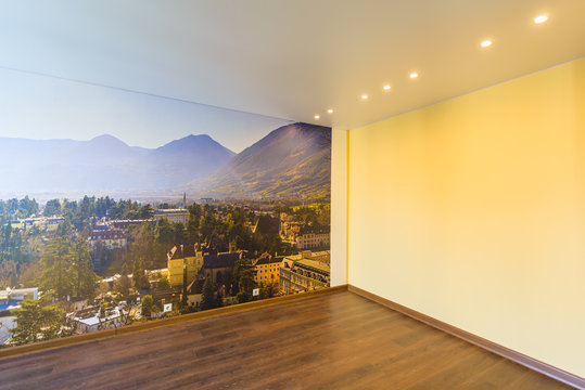Interior of an empty room in orange tones with a panorama photo wall mural Merano (South Tyrol, Italy)