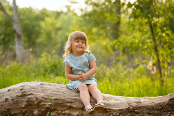 Naklejka na ściany i meble Little girl sitting on a tree