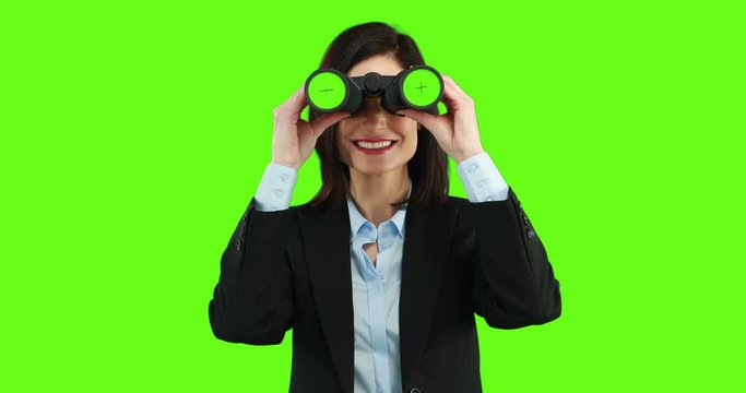 Businesswoman using binoculars on green screen
