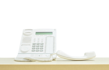 Closeup white phone , office phone on blurred wooden desk in the meeting room under window light isolated on white background