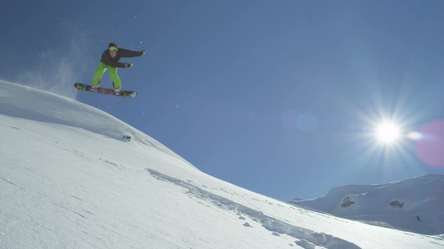 SLOW MOTION: Snowboarder jumps backflip in powder