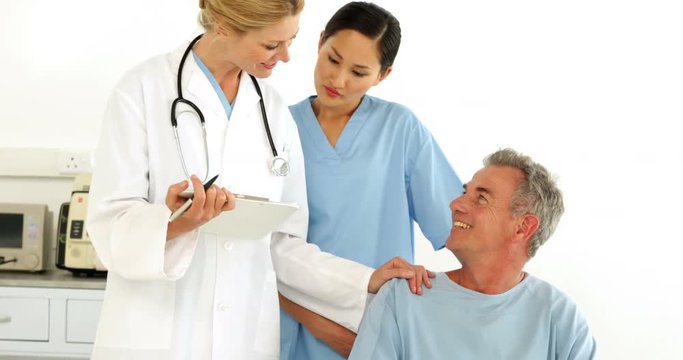 Friendly medical team talking with disabled patient