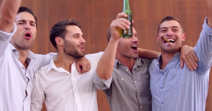 Friends having a drink and smocking cigars at a party