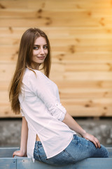 girl posing against background of a wooden wall