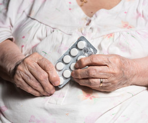 Old woman holding the medicine in hands