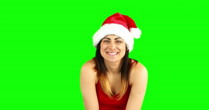 Pretty girl in santa hat sending an air kiss to camera on green screen