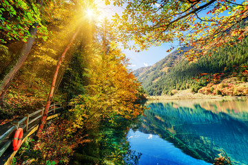 Fantastic view of amazing azure lake among colorful fall woods