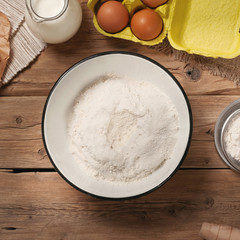 Fototapeta na wymiar Flour in bowl with Ingredients for cooking bakery products