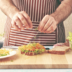 man cooking chicken sandwich