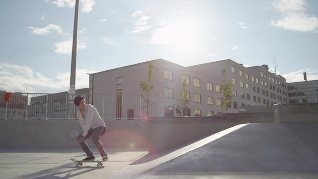 SLOW MOTION: Skateboarder riding and jumping in a skatepark