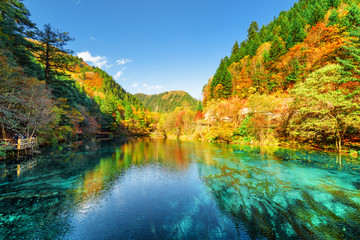 Colorful autumn forest reflected in the Five Flower Lake